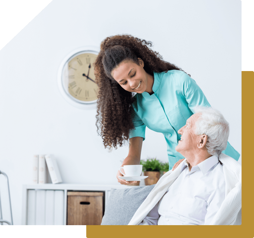 Caregiver smiling while serving tea to senior.