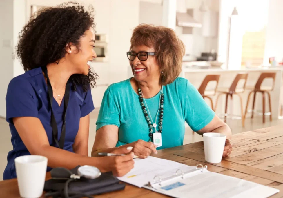 Healthcare worker talking with a smiling woman.